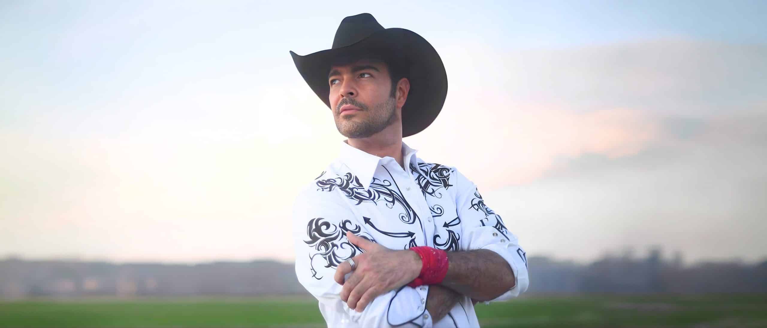 Pablo Montero con sombrero negro y camisa blanca bordada en retrato del cantante mexicano de música ranchera disponible para contratación en eventos